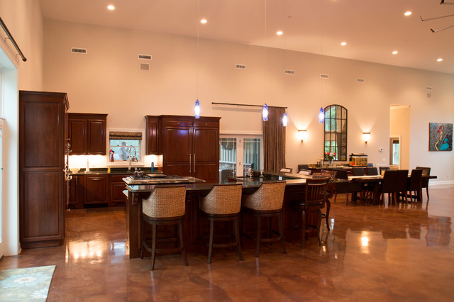 In the kitchen, the wooden cabinetry is a warm and inviting touch. The L-shaped island bar with seven stools is a great place to sit and chat while meals are being prepared. The dining area is located just beside the kitchen.