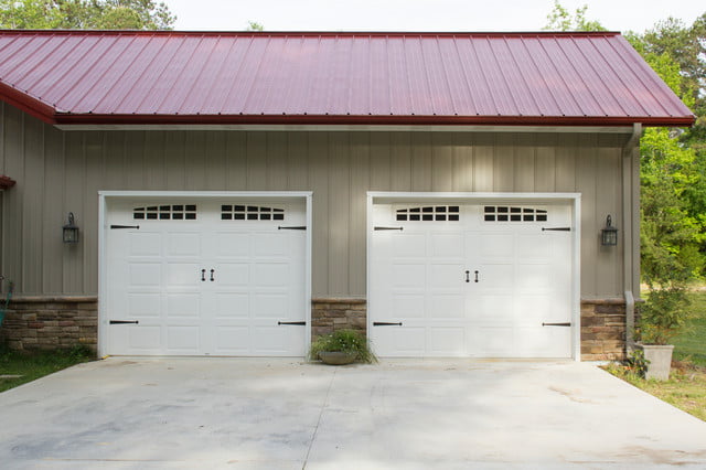 Two white garage doors stand out against the exterior of the house, providing both function and style.