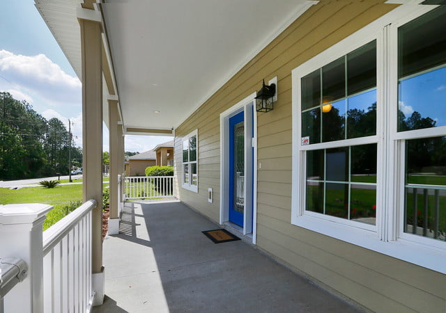 The front porch of this home is a charming and welcoming feature, with its blue door and large windows. The porch columns add a touch of elegance and structure to the space.