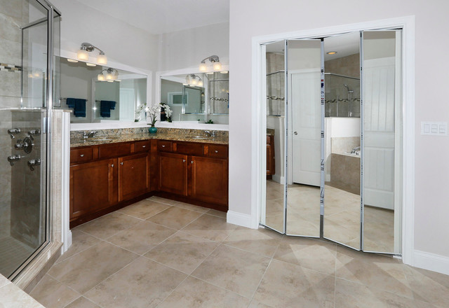 Sinks sits beneath large mirrors mounted on the wall. beside from the sink, a closet with mirrored doors takes up a portion of the room.