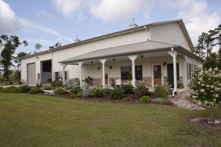 This beautiful home features a porch overlooking a cute flowerbed.