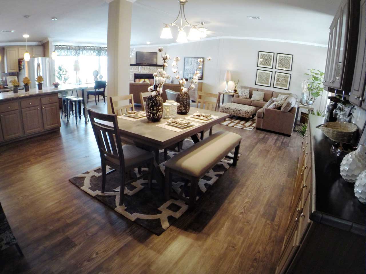 A beautifully set dining room table for six, with a cozy living room visible in the background.