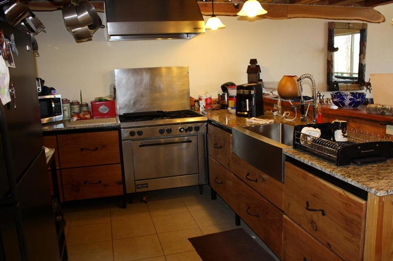 The kitchen is equipped with wooden cabinetry and radiates in rustic feel.