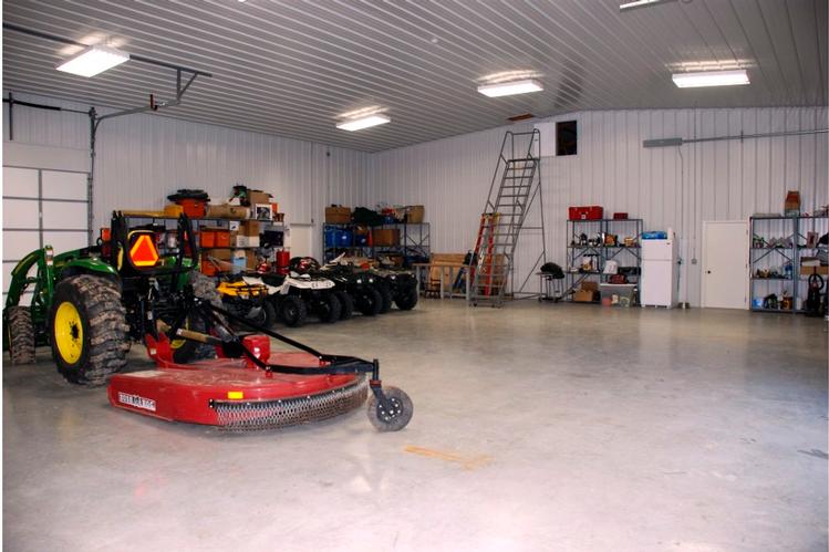 a spacious garage, with plenty of room for storing and organizing vehicles or other items. The clean, open layout and bright lighting make it easy to move around and work in this garage.