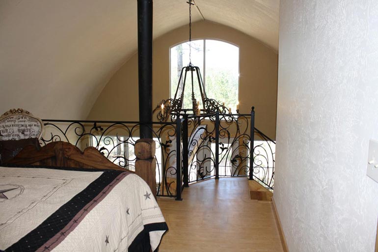 The loft bedroom of the Arched metal cabin.