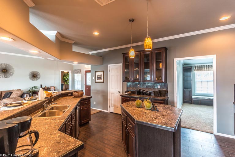 The kitchen boasts sleek wooden cabinetry and a large island in the middle, providing plenty of storage and workspace.