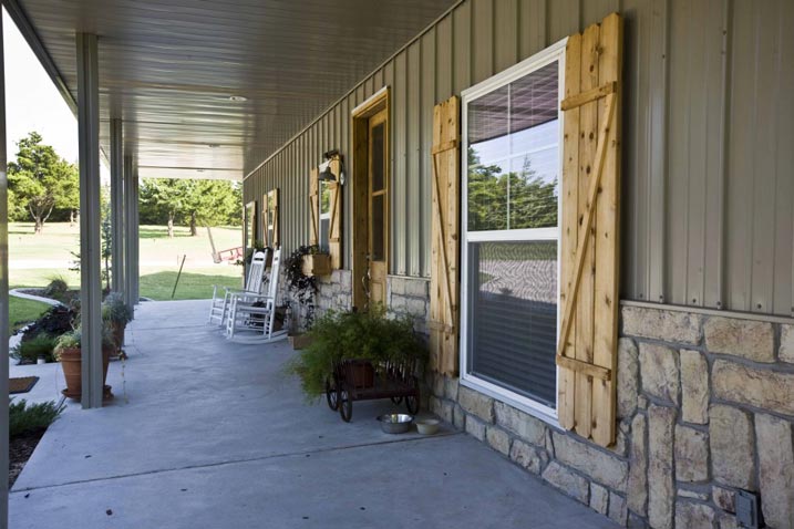 This close-up shot of the porch reveals the charming barn-like design of the windows. The rustic and welcoming feel of the porch is further enhanced by the natural wood beams and comfortable seating area.
