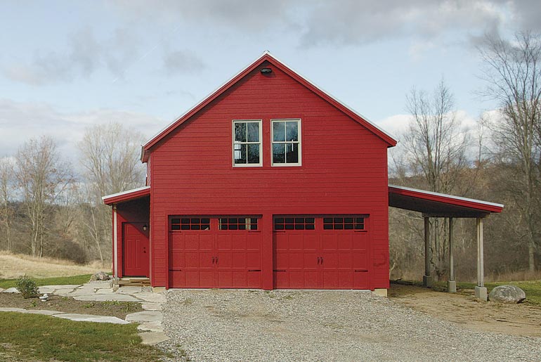 The farmhosue has a seperate garage that has the same design and color scheme.