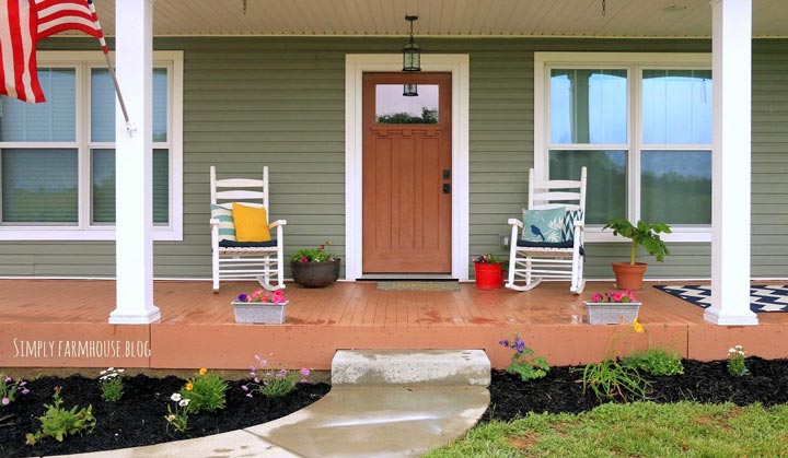 This closeup shot of the front porch reveals a sturdy brown platform with crisp white lining on the walls, inviting visitors to sit and relax.