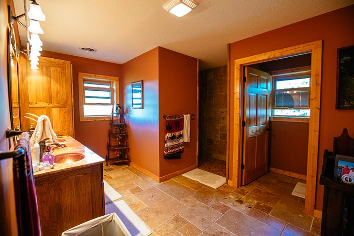 A bathroom designed to cater to the needs of a family features a spacious layout with multiple sinks and countertops, as well as ample storage space for towels, toiletries, and other bathroom essentials.