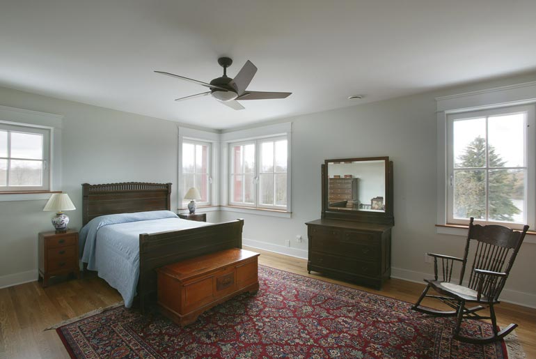 A cozy and spacious bedroom with a comfortable bed and plenty of natural light streaming in through the windows.
