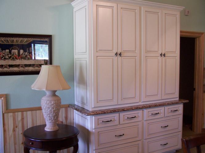 The bedroom features a large white cabinet for personal items.