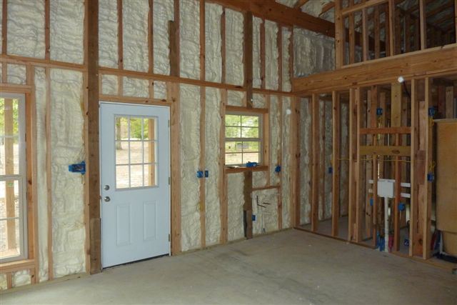 The wooden framing with the wall insulation seen