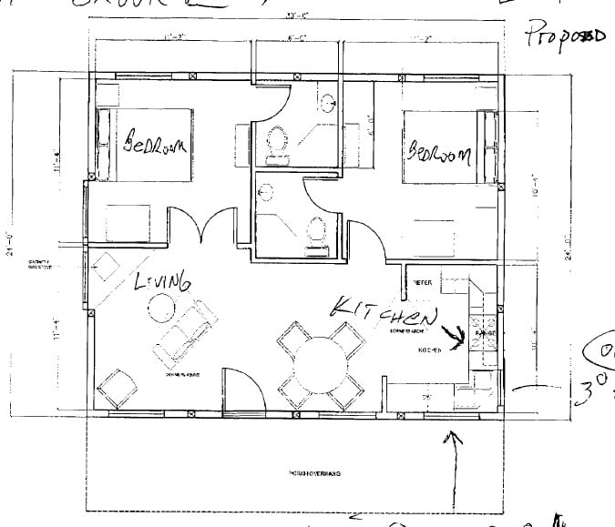Main level floor plan of the 24 x 30 Metal Building Home with patio, living room, kitchen, two bedrooms and bathrooms.