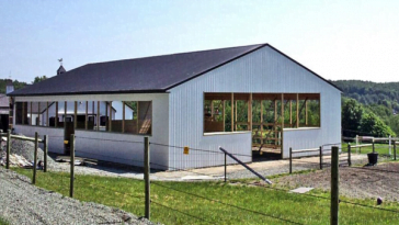 Duro steel building in white silver exterior and dar grey metal roof under the bright sky