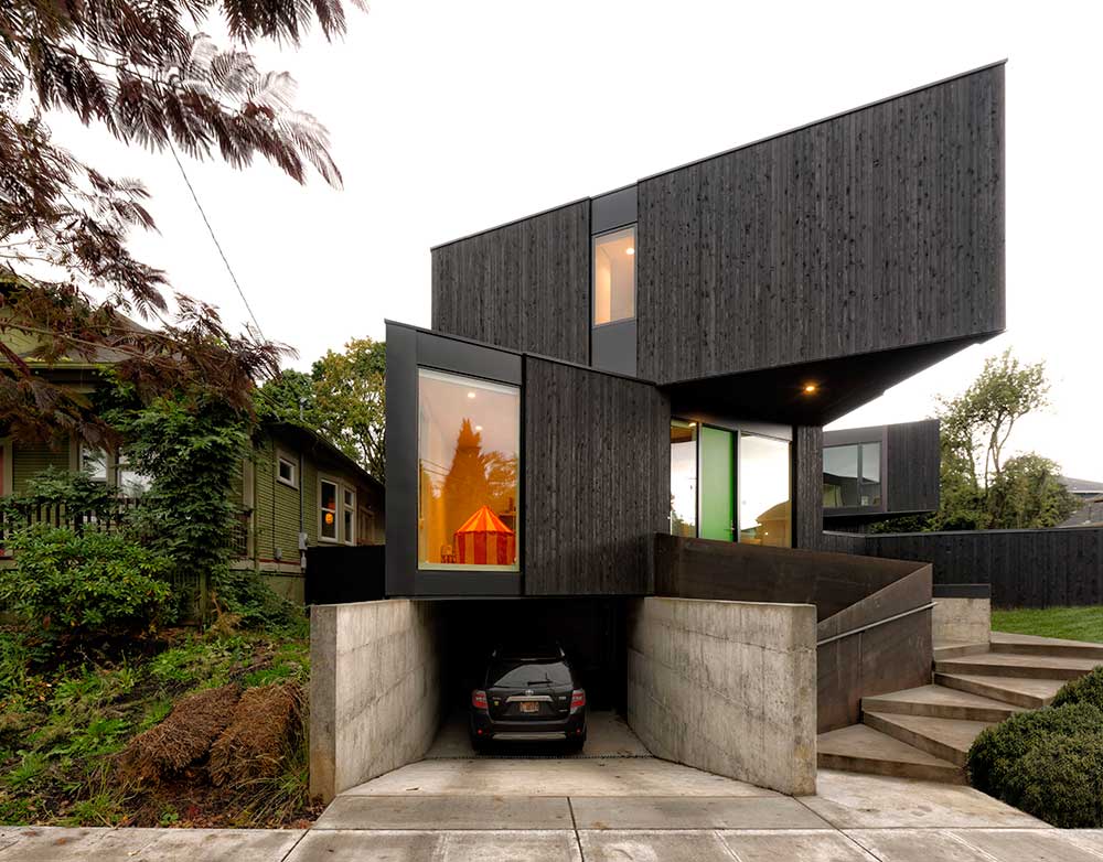 modern look prefabricated home with dark wood exterior and underground garage manufactured by Method homes