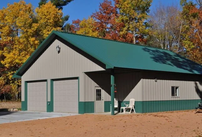 Metal building two-door garage and a workshop with green metal rood and light brown siding constructed by Wick Buildings