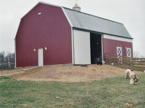Duro steel gambrel type building with red siding and big sliding barn doors