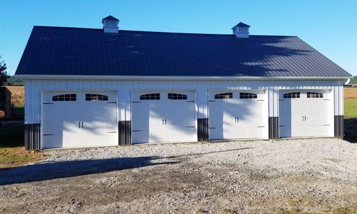 four door pole barn garage with metal siding and blue roof erected by stoltzfus builders