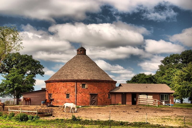 Old school red round style amish pole barn still in use for horses