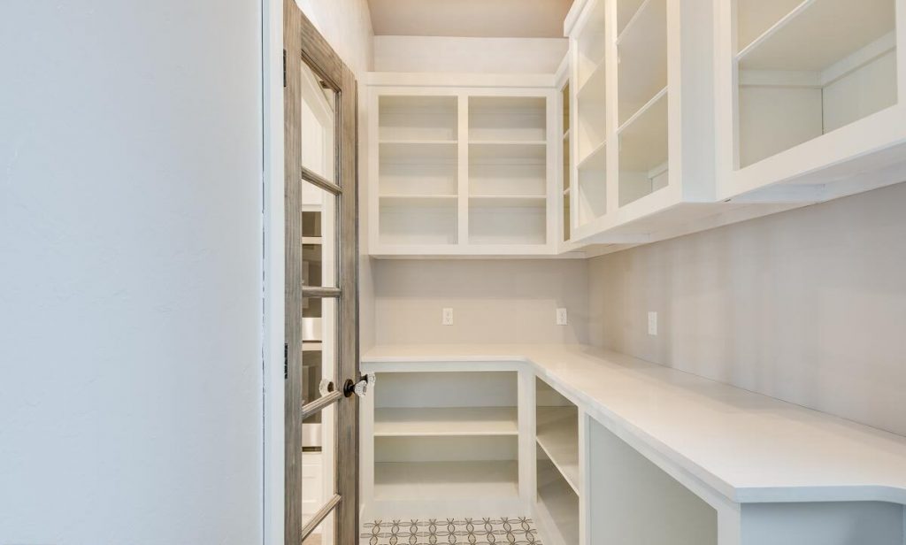 View from inside the pantry, shelves and cupboards are seen