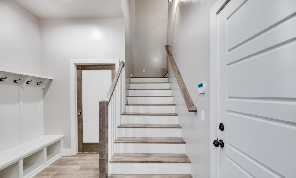 View of the stairs to the second floor and the laundry room entrance.