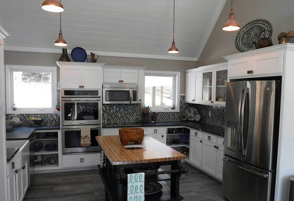 U-shaped kitchen equipped with white cabinets and a mini-island at the center.