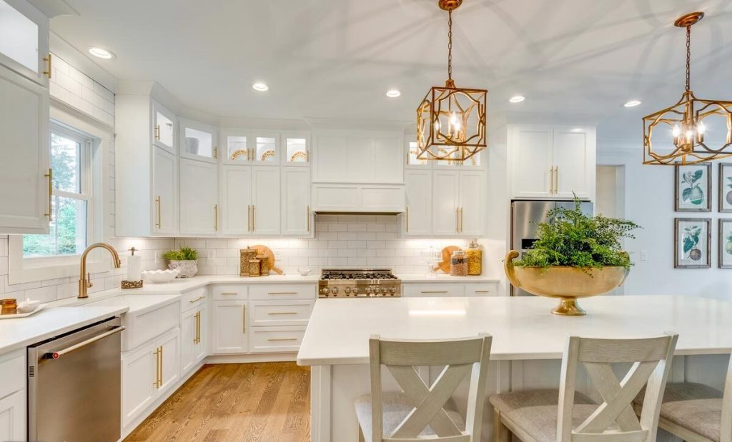 Kitchen area with a breakfast island table with 3 chairs, white cabinets