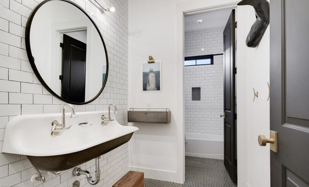 View of the the second bathroom with a classic sink and large mirror