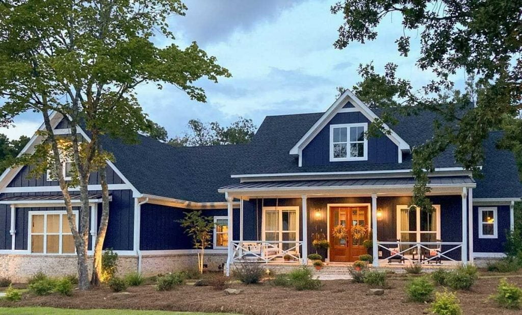 Front View of the 3 Car Garage 2 Story Modern Farmhouse in a blue scheme with its covered porch and large french windows 