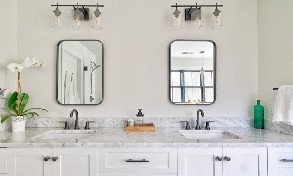 Marble top bathroom sink with mounted mirrors and lights