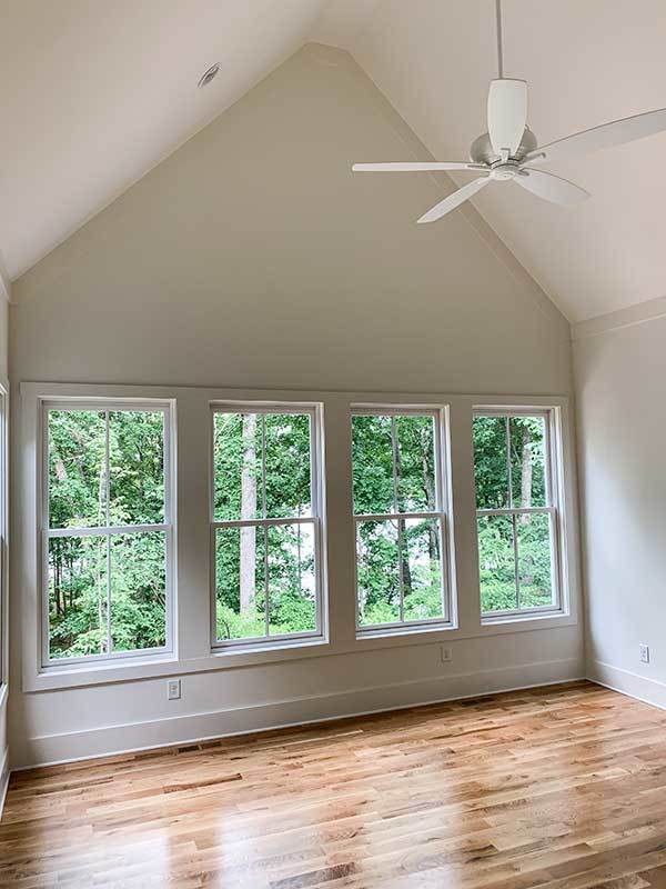 Room/studio with a extended downrod ceiling fan.