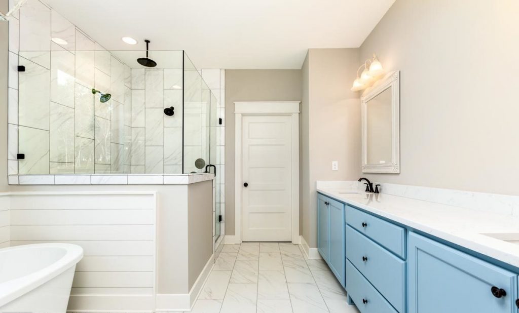 Bathroom with a standalone bathtub, walk-in shower, countertop with sinks and a wall mirror.