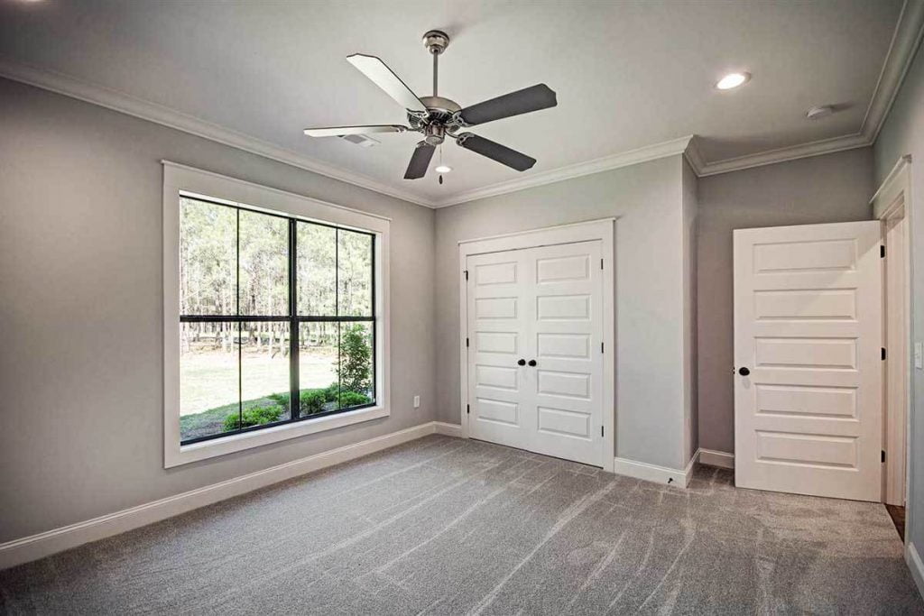 Bedroom showcasing carpet flooring, white trim, recessive lights and a walk-in closet.