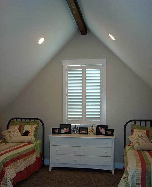 Bedroom 2 with a louver window, two twin beds and a white drawer at the middle.