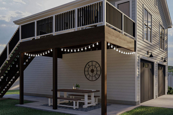 The covered patio is furnished with light bulb garlands and a picnic table.