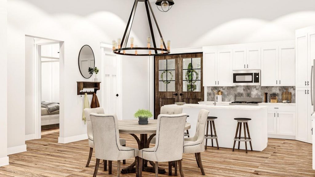 The dining area shows comfy cushioned dining chairs and wooden round table, a farmhouse chandelier, a round mirror, wooden stools, kitchen island and cabinets, and a wooden double door