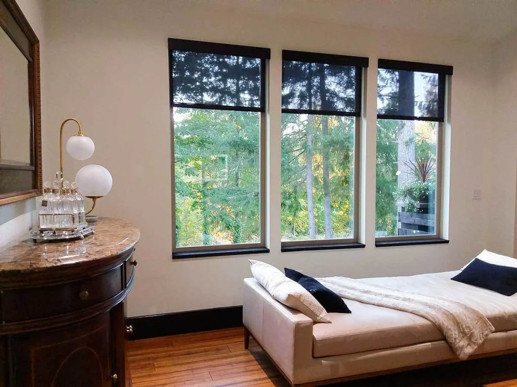View of the bedroom area with a single bed and 3 large windows