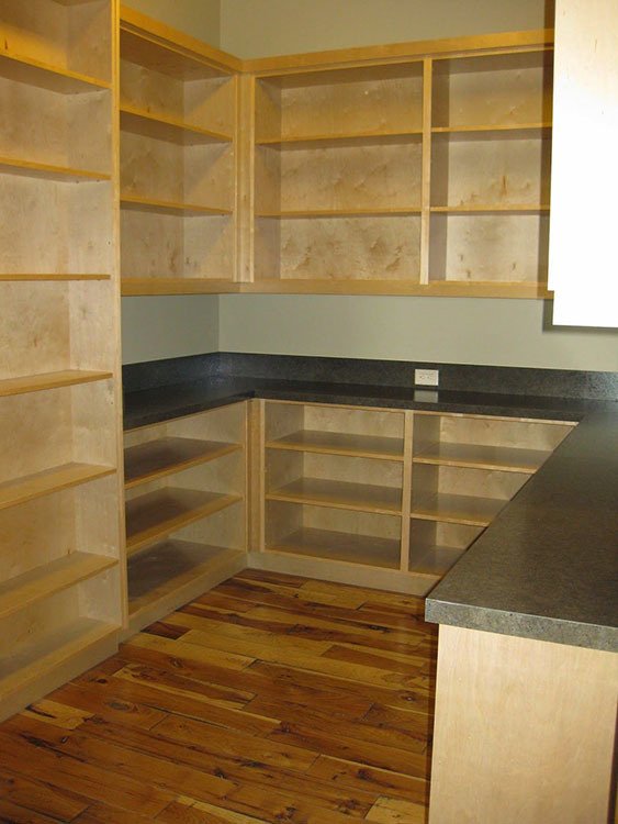 The pantry with marble countertops and wooden shelves.