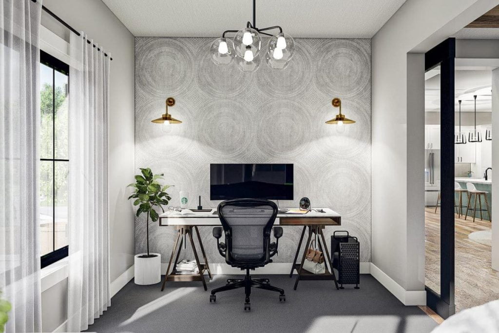 Home office with a wooden table, complete computer set, office chair, two mounbted lights are attached to a patterned wall