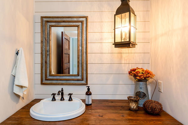 Sink with a rectangular mirror brightened by a classic lantern.