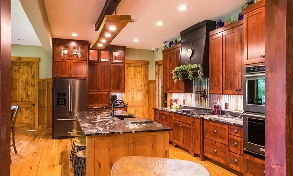 Well-lit kitchen equipped with center island, wooden cabinetry, and stainless steel appliances.  