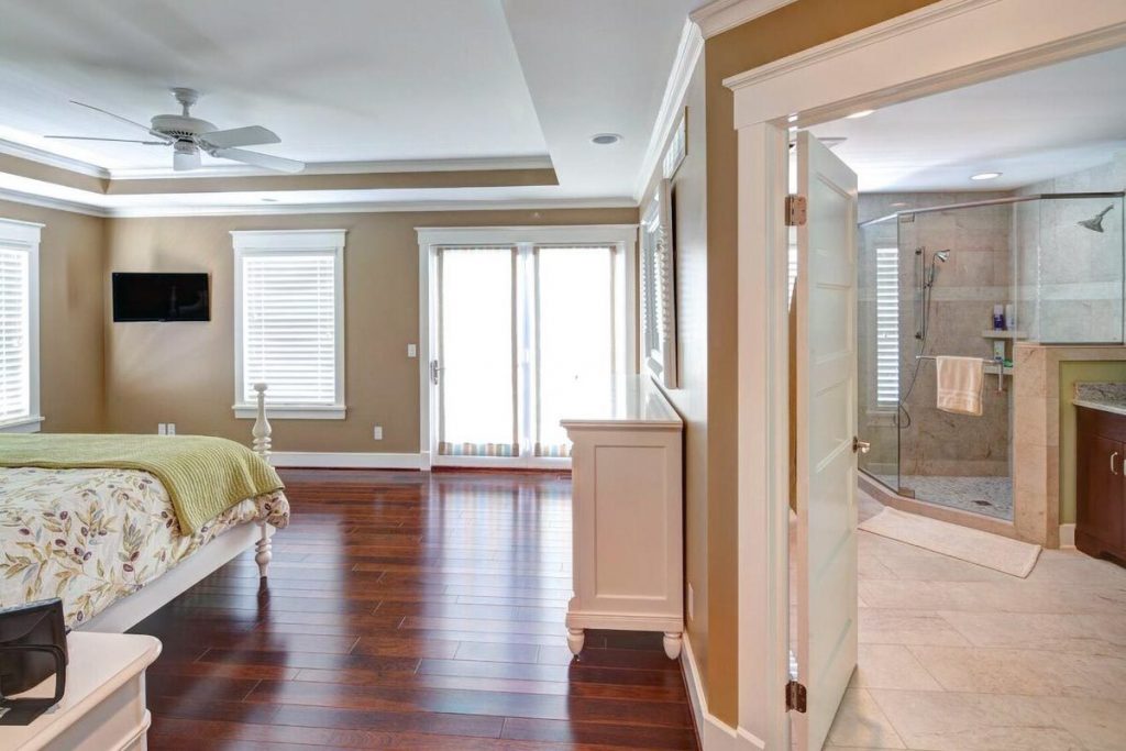 An open layout view showing the master bedroom, master bathroom, and the glass door leading to the private deck.