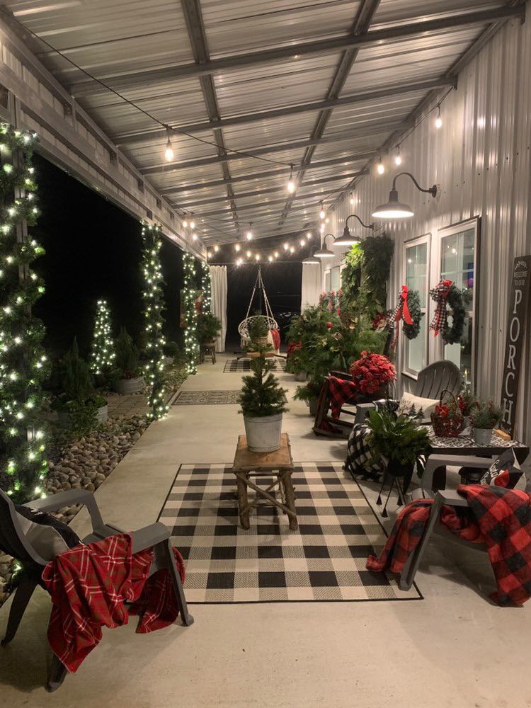 Rear porch adorned with lounging chairs plants and Christmas lights