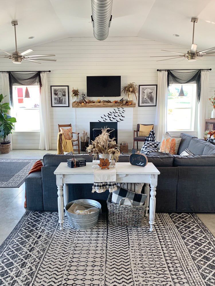 The Living Room, with a fireplace, furnished with a sectional sofa, and a tv. 