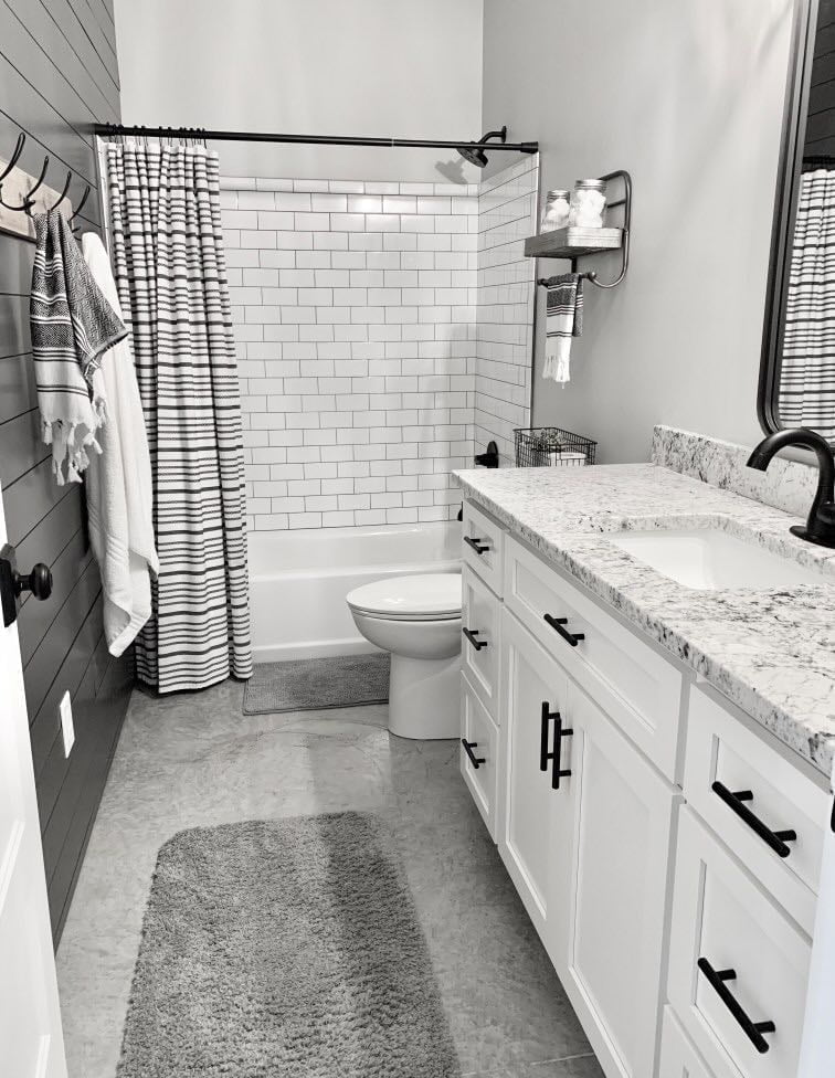 A bathroom, complete with a shower-bath, toilet, and vanity-sink set