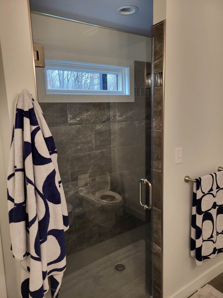 Bathroom with a glass shower door and tiled walls