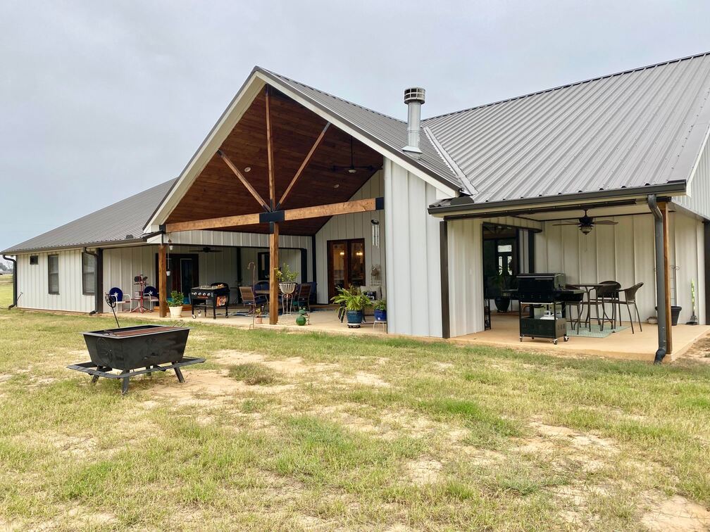 Front view with the spacious porch adorned with cozy chairs and tables