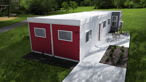 A 960 sq. ft. shipping container home by Custom Container Living with white and red exteriors.