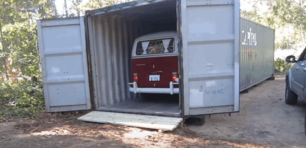 A volkswagen beetle van inside a shipping container garage